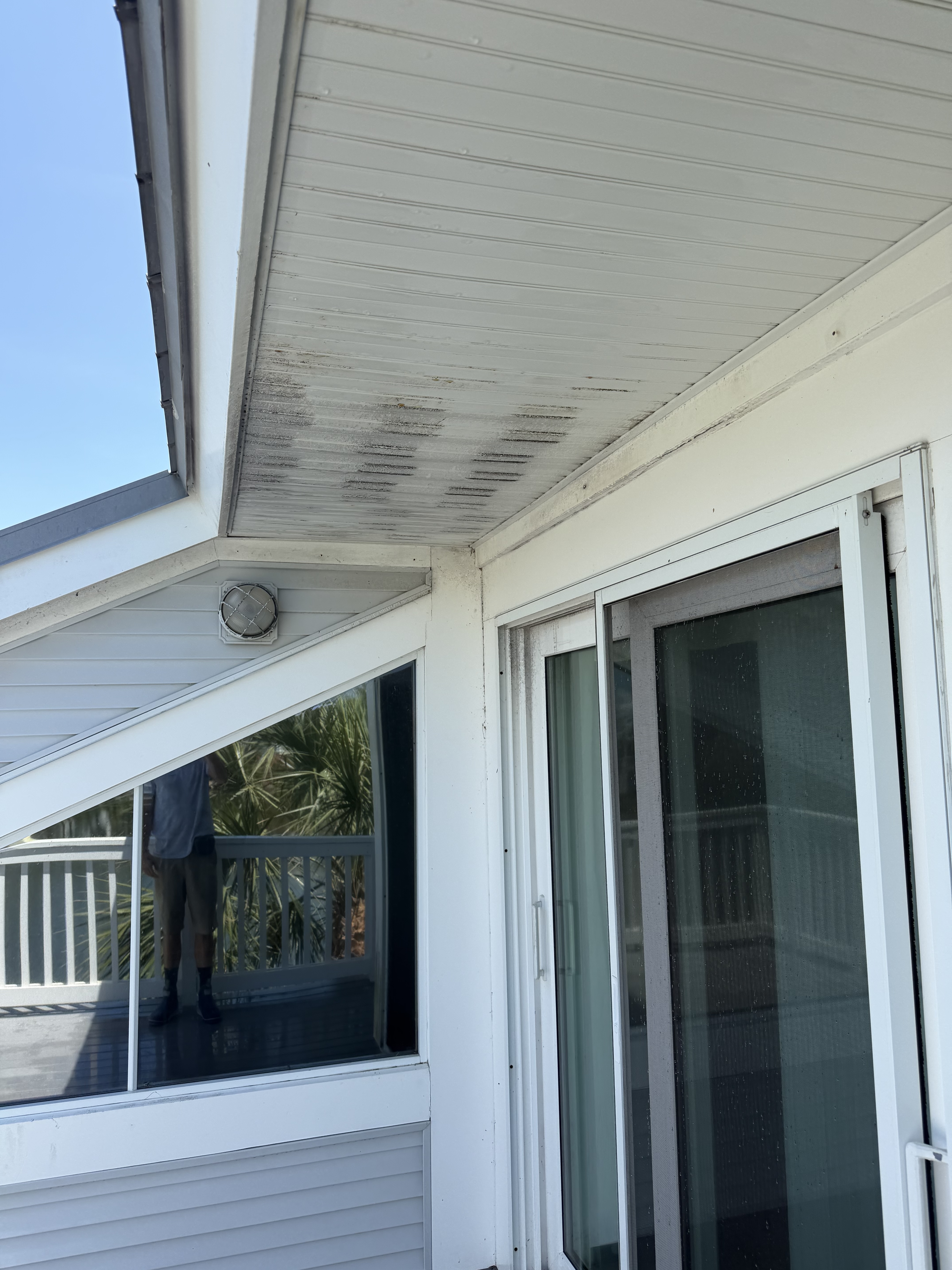 Third-story exterior before and after — soffit, sliders, and glass cleaned.