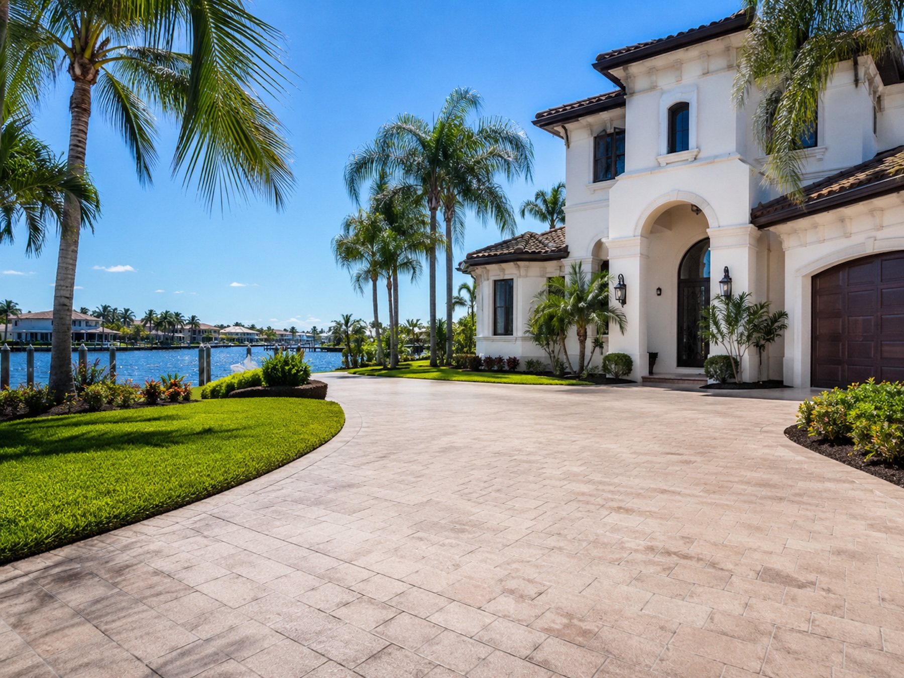 Illustrative driveway rinse — wide light-gray paver drive beside a modern home.